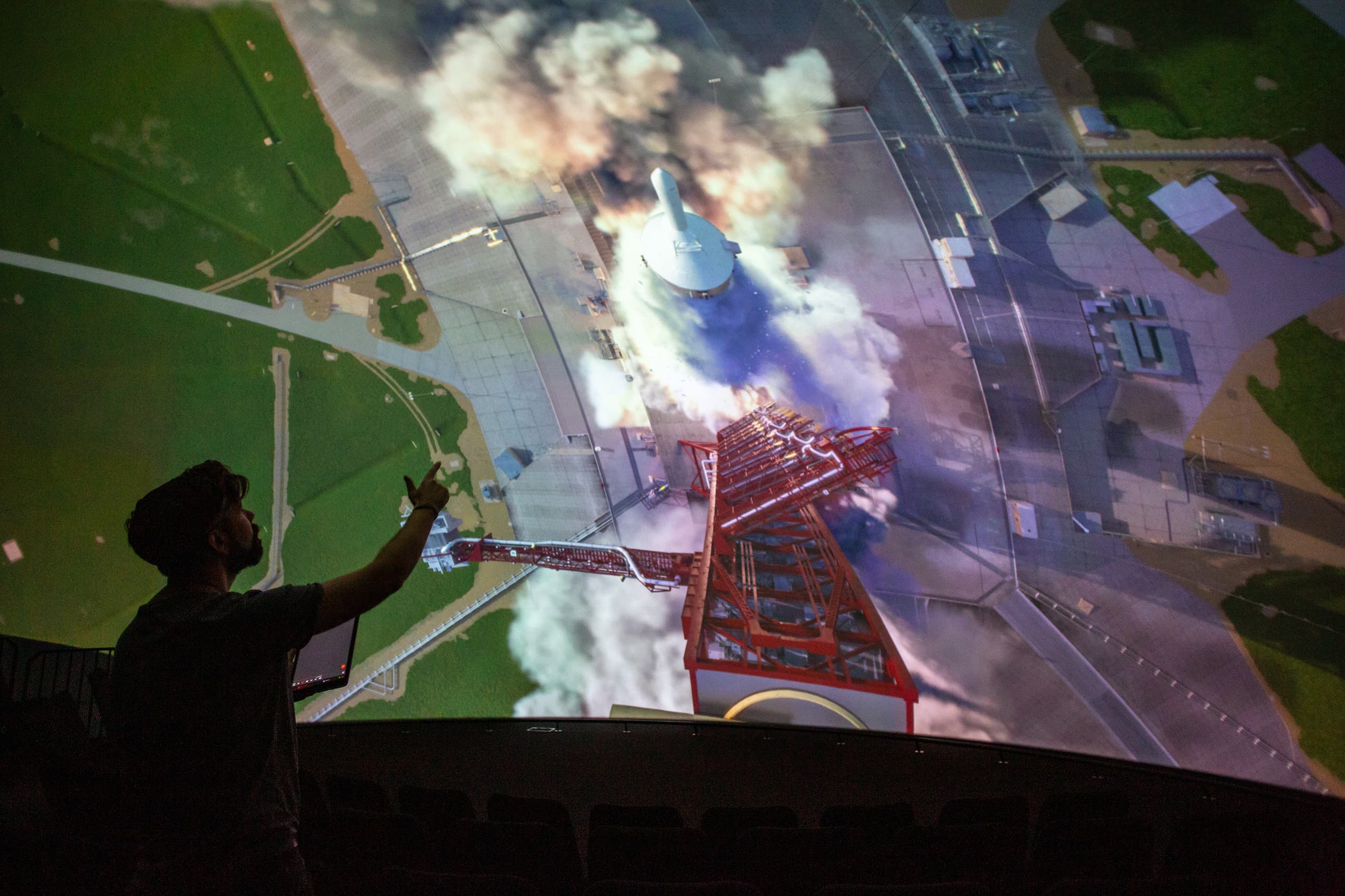 A person standing in front of a curved screen with immersive projection powered by Screenberry media server