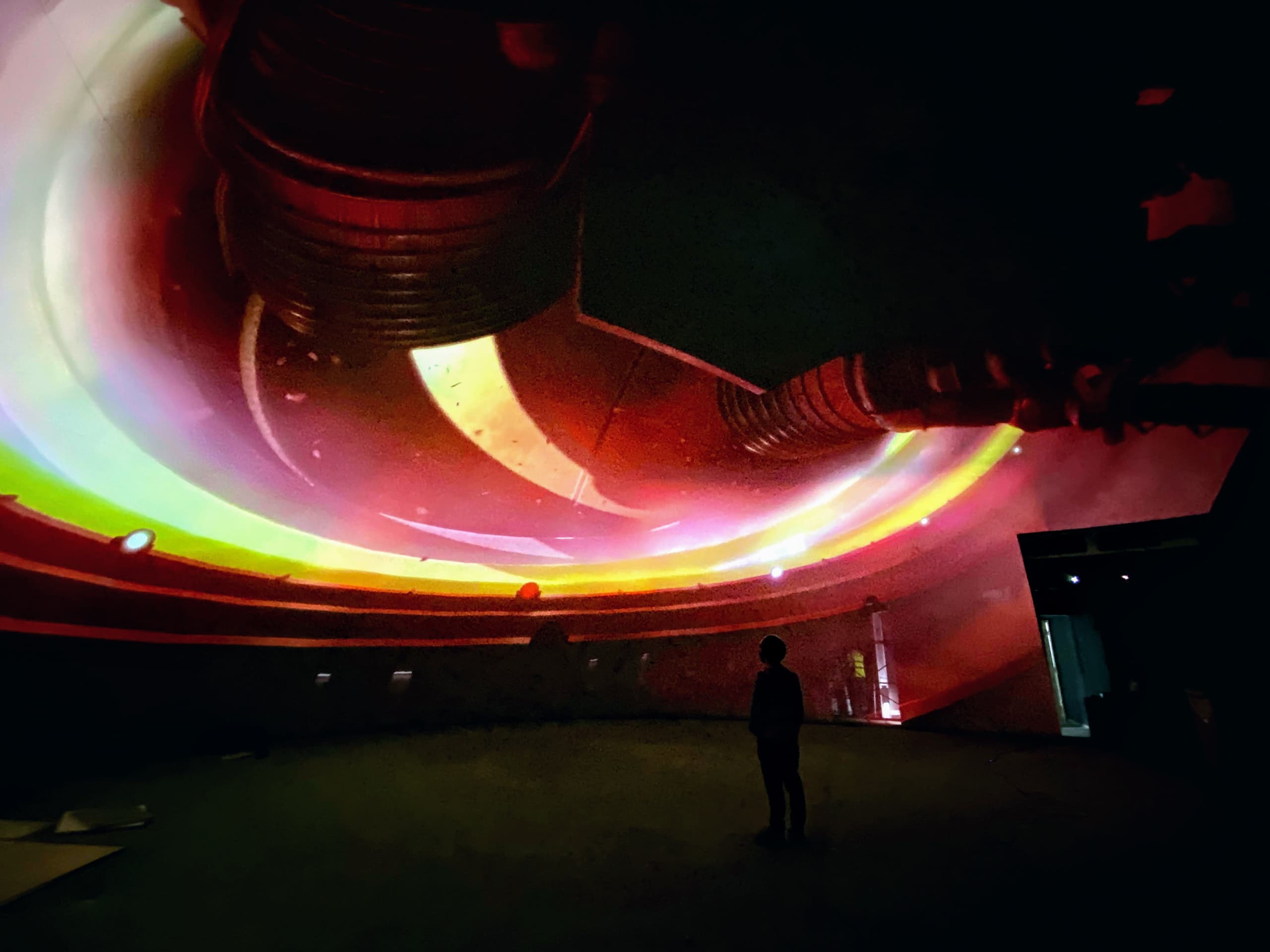 A person standing in front of a curved screen with immersive projection powered by Screenberry media server