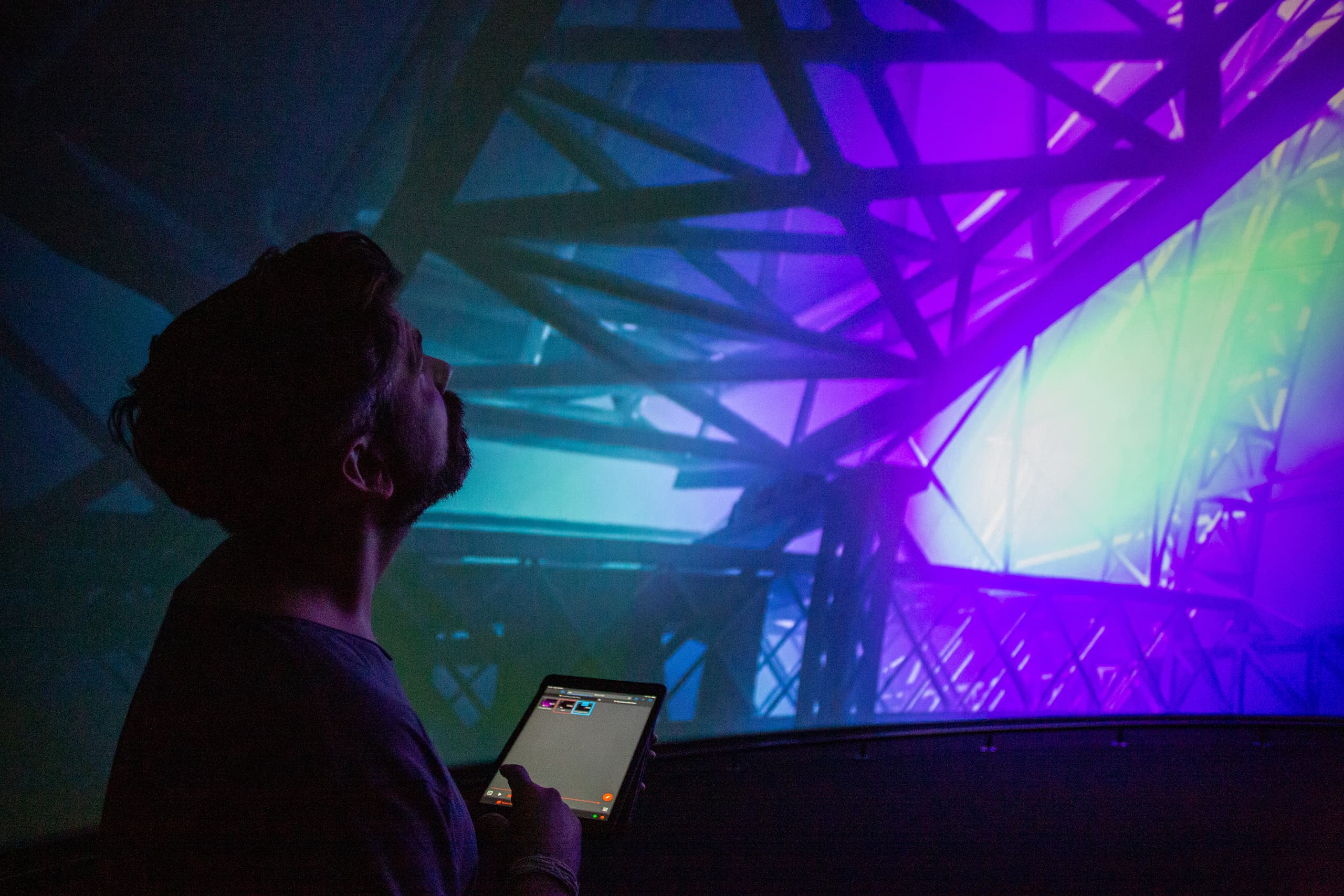 A person standing in front of a curved screen with immersive projection powered by Screenberry media server