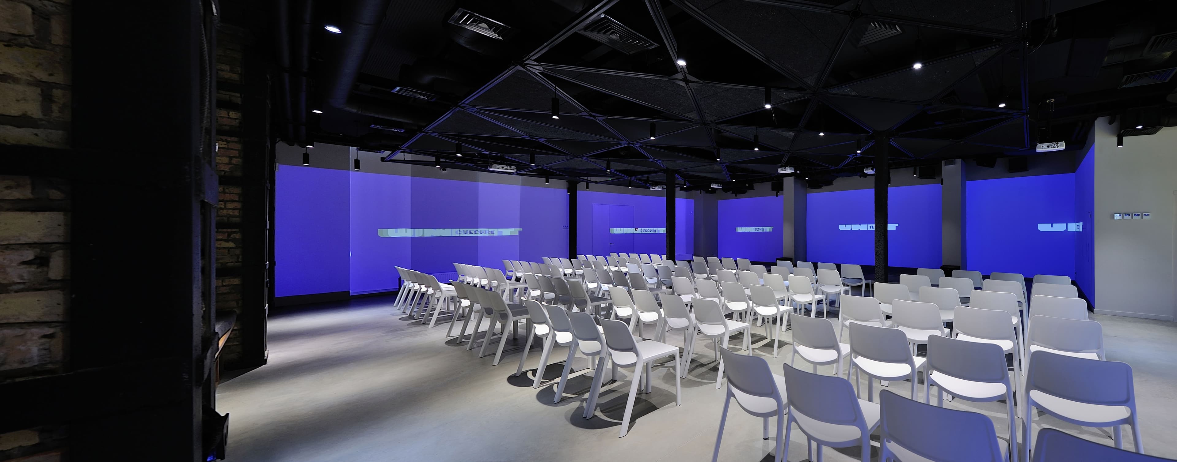 Multiple projected screens at a Unit.City conference hall